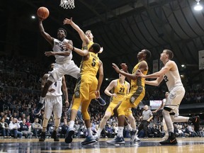 Butler guard Kamar Baldwin (3) shoots between Marquette defenders Sam Hauser and Greg Elliott (5) during the first half of an NCAA college basketball game in Indianapolis, Friday, Jan. 12, 2018.