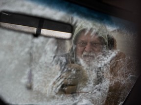 CORRECTS SPELLING TO FALSETTI NOT FALSETTO - Mike Falsetto cleans the ice from his windshield Friday, Jan. 12, 2018, in South Bend, Ind. Friday's return of cold temperatures, ice and snow was a contrast with Thursday's record breaking high temperatures in South Bend.