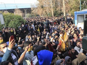 In this Saturday, Dec. 30, 2017 file photo taken by an individual not employed by the Associated Press and obtained by the AP outside Iran, university students attend a protest inside Tehran University while anti-riot Iranian police prevent them to join other protestors, in Tehran, Iran.