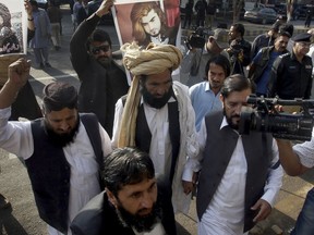 Muhammad Ahmed Mehsud, center, father of Naqeebullah Mehsud, who was killed in a police shoot-out, arrives at a court in Karachi, Pakistan, Saturday, Jan. 27, 2018. A Pakistani lawyer says the country's court has given three days to police to arrest an absconding officer who is involved in killing an aspiring model in a 'fake shootout' labeling him as 'terrorist'.