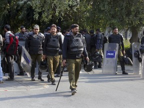 Pakistani police officers with riot gear stand guard at the University of Punjab following clashes between two student groups, in Lahore, Pakistan, Jan. 22, 2018. Students linked to rival groups, one linked with a radical Islamic party, the other with nationalists, have clashed at the prestigious university, with dozens reported hurt in the skirmishes.