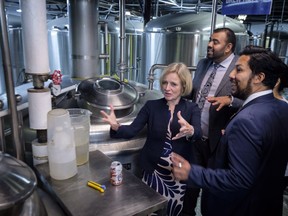 Alberta Premier Rachel Notley, right, gestures as she tours a microbrewery in Calgary, Alta., Thursday, Jan. 18, 2018.THE CANADIAN PRESS/Jeff McIntosh