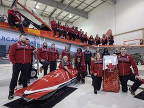 Athletes named the Canadian Olympic bobsled and skeleton teams stand on and sit in front of a Canadian Forces CF-18 after the naming of the teams in Calgary, Alta., Wednesday, Jan. 24, 2018.THE CANADIAN PRESS/Jeff McIntosh
