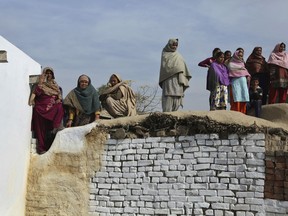 Indian village women look on as relatives wail near the body of Indian teenage girl Neelam Devi, before her funeral in Pindi in Arnia district of Jammu and Kashmir, India, Thursday, Jan.18, 2018. Indian officials say the teenage girl and a soldier have been killed by Pakistani troops firing along the volatile frontier in Indian-controlled Kashmir.