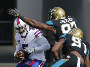 Buffalo Bills quarterback Tyrod Taylor, left, is sacked by Jacksonville Jaguars defensive tackle Malik Jackson, center, and defensive end Yannick Ngakoue (91) in the first half of an NFL wild-card playoff football game, Sunday, Jan. 7, 2018, in Jacksonville, Fla.