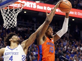 Florida's Kevarrius Hayes (13) pulls down a rebound near Kentucky's Nick Richards (4) during the first half of an NCAA college basketball game, Saturday, Jan. 20, 2018, in Lexington, Ky.
