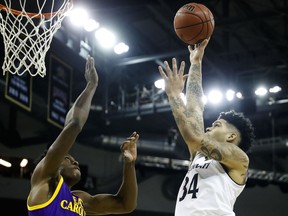 Cincinnati's Jarron Cumberland (34) shoots against ECU's Jabari Craig, left, in the first half of an NCAA college basketball game, Saturday, Jan. 20, 2018, in Highland Heights, Ky.