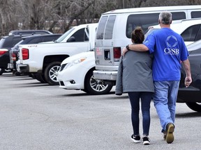 Family members escort their children out of Marshal North Middle School near Palma, Ky., Tuesday, Jan. 23, 2018, after the students where transported from Marshal High School. The students were transported to the middle school to be picked up by family members after a deadly shooting at the high school.