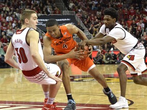 Virginia Tech guard Nickeil Alexander-Walker (4) drives into the defense of Louisville guard Ryan McMahon (30) as Louisville guard Darius Perry (2) attempts a steal during the first half of an NCAA college basketball game, Saturday, Jan. 13, 2018, in Louisville, Ky.