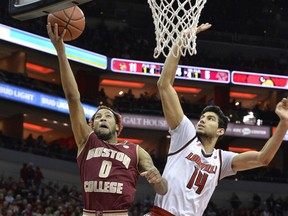 Boston College guard Ky Bowman (0) attempts a layup past the defense of Louisville forward Anas Mahmoud (14) during the first half of an NCAA college basketball game, Sunday, Jan. 21, 2018, in Louisville, Ky.