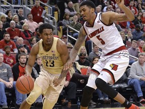 Wake Forest guard Bryant Crawford (13) attempts to drive past Louisville forward Malik Williams (5) during the first half of an NCAA college basketball game Saturday, Jan. 27, 2018, in Louisville, Ky.