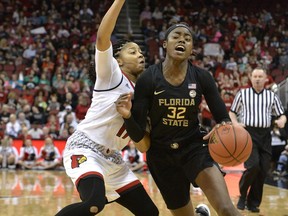 Florida State guard Imani Wright (32) fights her way around the defense of Louisville guard Arica Carter (11) during the first half of an NCAA college basketball game, Sunday, Jan. 21, 2018, in Louisville, Ky.