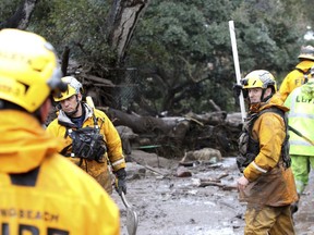 Members of the Long Beach Search and Rescue team head into a debris-soaked area of Montecito, Calif. to look for survivors on Tuesday, Jan. 9, 2018. Several homes were swept away before dawn Tuesday when mud and debris roared into neighborhoods in Montecito from hillsides stripped of vegetation during a recent wildfire.