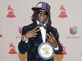 FILE - This Nov. 20, 2014 file photo shows rapper Flavor Flav, whose real name is William Jonathan Drayton Jr., at the 15th annual Latin Grammy Awards in Las Vegas. Police in Las Vegas say Ugandi Howard, 44, is facing a misdemeanor battery charge for attacking the entertainer at a local casino. Officer Laura Meltzer said, Thursday, Jan. 25, 2018, that Drayton was taken to a hospital for treatment of minor injuries after the incident on Tuesday. Howard was issued a summons to appear March 6 in Las Vegas Justice Court.