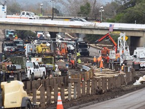In this Friday, Jan. 19, 2018 photo Caltrans and other workers continue their around-the-clock efforts to clean-up and repair the damaged section of US 101 in Montecito, Calif., that was closed following flooding on Jan. 9. California officials say key coastal highway swamped by deadly mudslides has reopened Sunday, Jan 21, 2018, after nearly 2-week closure.