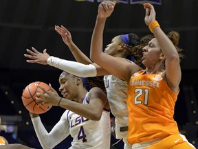 LSU forward Raven Farley (4) pulls in a rebound in front of teammate Ayana Mitchell, center, and Tennessee center Mercedes Russell (21) in the first half of an NCAA college basketball game, Sunday, Jan. 28, 2018, in Baton Rouge, La.