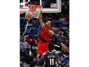 Portland Trail Blazers guard Damian Lillard (0) dunks over New Orleans Pelicans guard Jrue Holiday (11) during the first half of an NBA basketball game in New Orleans, Friday, Jan. 12, 2018.