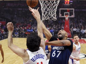 Minnesota Timberwolves forward Taj Gibson, right, shoots as Los Angeles Clippers guard Milos Teodosic, of Serbia, defends during the first half of an NBA basketball game, Monday, Jan. 22, 2018, in Los Angeles.