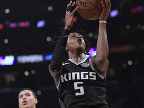 Sacramento Kings guard De'Aaron Fox, right, shoots as Los Angeles Lakers forward Kyle Kuzma defends during the first half of an NBA basketball game Tuesday, Jan. 9, 2018, in Los Angeles.