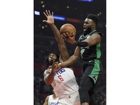 Boston Celtics guard Jaylen Brown, right, shoots as Los Angeles Clippers center DeAndre Jordan defends during the first half of an NBA basketball game Wednesday, Jan. 24, 2018, in Los Angeles.
