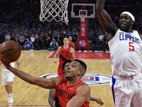 Portland Trail Blazers guard CJ McCollum, left, shoots as Los Angeles Clippers forward Montrezl Harrell, right, defends during the first half of an NBA basketball game, Tuesday, Jan. 30, 2018, in Los Angeles.
