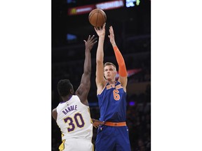 New York Knicks forward Kristaps Porzingis, right, of Latvia, shoots as Los Angeles Lakers forward Julius Randle defends during the first half on an NBA basketball game, Sunday, Jan. 21, 2018, in Los Angeles.