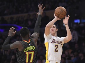 Los Angeles Lakers guard Lonzo Ball, right, shoots as Atlanta Hawks guard Dennis Schroder, of Germany, defends during the first half of a basketball game, Sunday, Jan. 7, 2018, in Los Angeles.