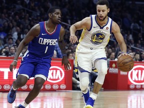 Golden State Warriors guard Stephen Curry, right, dribbles around Los Angeles Clippers guard Jawun Evans during the second half of an NBA basketball game in Los Angeles, Saturday, Jan. 6, 2018. Behind Curry's 45 points, the Warriors won 121-105.