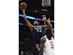 Minnesota Timberwolves center Karl-Anthony Towns, left, shoots as Los Angeles Clippers forward Montrezl Harrell defends during the second half of an NBA basketball game, Monday, Jan. 22, 2018, in Los Angeles. The Timberwolves won 126-118.