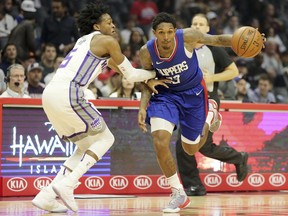 Sacramento Kings guard De'Aaron Fox (5) defends as Los Angeles Clippers guard Lou Williams (23) drives in the first period of an NBA basketball game in Los Angeles Saturday, Jan. 13, 2018.