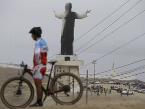 A man rests with his bicycle near the Cristo del Pacifico (Christ of the Pacific) statue in Lima, Peru, on Saturday, Jan. 13, 2018. The replica of the Christ the Redeemer Statue in Rio de Janeiro was set on fire days before Pope Francis is scheduled to arrive in the South American nation.