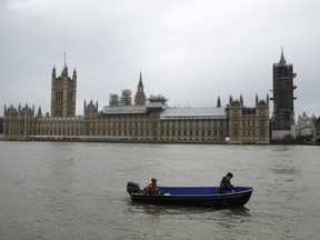 People aboard a boat make way past the Houses of Parliament with Big Ben's clock tower, the Elizabeth Tower covered in scaffolding for repairs in London, Wednesday, Jan. 31, 2018. Experts have issued increasingly urgent warnings about the state of the neo-Gothic 19th-century parliament building, and lawmakers are set to vote Wednesday on what to do about the crumbling, leaky, vermin infested building which will take years to fix and cost billions.