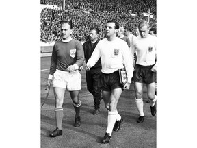 FILE - This is a Oct. 23, 1963 file photo of England captain Jimmy Armfield, front right,  leading out England for the match against the Rest of the World led by Alfredo Di Stefano, front left,  for the Football Association Centenary soccer match at Wembley Stadium, London.  Jimmy Armfield, a former England captain who led Leeds to the European Cup final as a manager before a distinguished career in broadcasting,  died Monday Jan. 22, 2018. He was 82. (AP Photo/File)