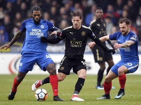 Leicester City's Adrien Silva battles for the ball with Peterborough United's Danny Lloyd, right, and Anthony Grant during the English FA Cup, fourth round soccer match at The ABAX Stadium, Peterborough, England, Saturday Jan. 27, 2018.