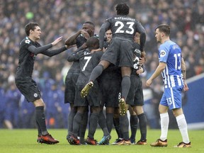 Chelsea's Eden Hazard, obscured, celebrates with team members after scoring his side's first goal of the game against Brighton and Hove Albion, during the English Premier League soccer match between Chelsea and  Brighton and Hove Albion, at the AMEX Stadium in Brighton, England, Saturday Jan. 20, 2018.