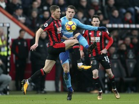 Arsenal's Granit Xhaka, center, is challenged by Bournemouth's Dan Gosling during the English Premier League soccer match against Bournemouth at the Vitality Stadium, Bournemouth, England, Sunday Jan. 14, 2018.