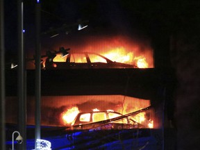 Vehicles burn during a blaze at a multi-storey car park at the Echo Arena on the waterfront in Liverpool, England Sunday, Dec. 31, 2017. An evening session of the Liverpool International Horse Show taking place in the Echo Arena was cancelled after horses were evacuated to safety. No one is known to have been injured in the fire.