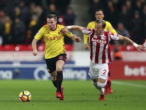 Watford's Tom Cleverley, left, battles for the ball with Stoke City's Moritz Bauer during their English Premier League soccer match at the bet365 Stadium, Stoke, England, Wednesday, Jan. 31, 2018.