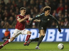 Bristol City's Jamie Paterson, left, and Manchester City's Leroy Sane battle for the ball during the English League Cup semi final, second leg match at Ashton Gate, Bristol, England, Tuesday, Jan. 23, 2018.