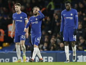 Chelsea's Cesc Fabregas, centre, Gary Cahill, left, and Tiemoue Bakayoko look dejected after Bournemouth's third goal during the English Premier League soccer match between Chelsea and Bournemouth at Stamford Bridge in London, Wednesday Jan. 31, 2018.
