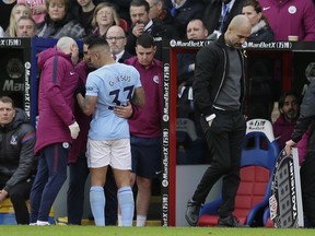 Manchester City manager Pep Guardiola, right, looks dejected as Manchester City's Gabriel Jesus is taken off the pitch injured during the English Premier League soccer match between Crystal Palace and Manchester City at Selhurst Park in London, Sunday Dec. 31, 2017.