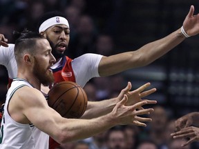 Boston Celtics center Aron Baynes, foreground, and New Orleans Pelicans forward Anthony Davis, rear, battle for a rebound during the first quarter of an NBA basketball game in Boston, Tuesday, Jan. 16, 2018.