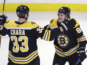 Boston Bruins right wing David Pastrnak, right, celebrates his goal off Montreal Canadiens goaltender Carey Price with defenseman Zdeno Chara (33) during the first period of an NHL hockey game in Boston, Wednesday, Jan. 17, 2018.