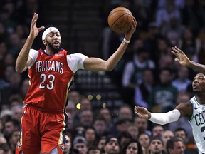 New Orleans Pelicans forward Anthony Davis (23) grabs a rebound against Boston Celtics guard Marcus Smart (36) during the first quarter of an NBA basketball game in Boston, Tuesday, Jan. 16, 2018.