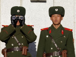 North Korean soldiers look at South Korea across the Korean Demilitarized Zone (DMZ), on December 22, 2011 in Panmunjom, South Korea.