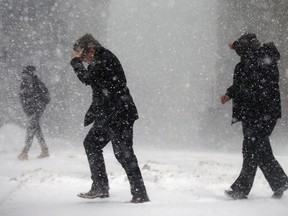 Pedestrians cross the street in downtown Boston, Thursday, Jan. 4, 2018. A massive winter storm swept from the Carolinas to Maine on Thursday, dumping snow along the coast and bringing strong winds that will usher in possible record-breaking cold.