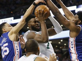 Boston Celtics' Jaylen Brown (7) drives for the basket against Philadelphia 76ers' Ben Simmons (25) and Joel Embiid, right, during the fourth quarter of an NBA basketball game in Boston, Thursday, Jan. 18, 2018.