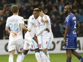 Marseille's players celebrate after Marseille's Clinton Mua Njie, center, scored during the League One soccer match between Marseille and Strasbourg, at the Velodrome stadium, in Marseille, southern France, Tuesday, Jan. 16, 2018.