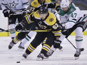 Boston Bruins left wing Brad Marchand (63) and Dallas Stars right wing Alexander Radulov (47), of Russia, vie for control of the puck during the first period of an NHL hockey game, Monday, Jan. 15, 2018, Boston.