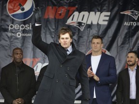 New England Patriots quarterback Tom Brady, center left, tosses a microphone after addressing a crowd during an NFL football Super Bowl send-off rally, Monday, Jan. 29, 2018, in Foxborough, Mass., as free safety Devin McCourty, left, tight end Rob Gronkowski, center right, and wide receiver Danny Amendola, right, look on. The Patriots are to play the Philadelphia Eagles in Super Bowl 52, Sunday, Feb. 4, in Minneapolis.